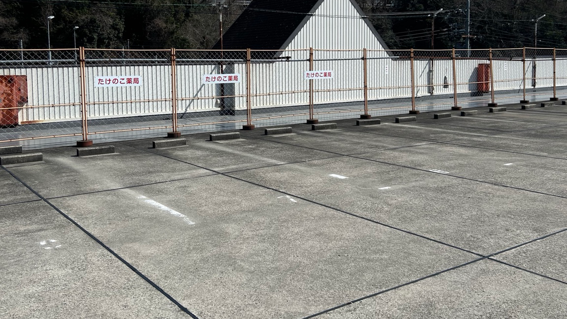 光陽台店の駐車場。フェンスに赤字のたけのこ薬局表示があります