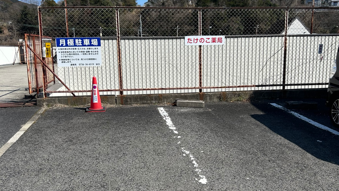 駐車区画の目印になる赤字のたけのこ薬局表示